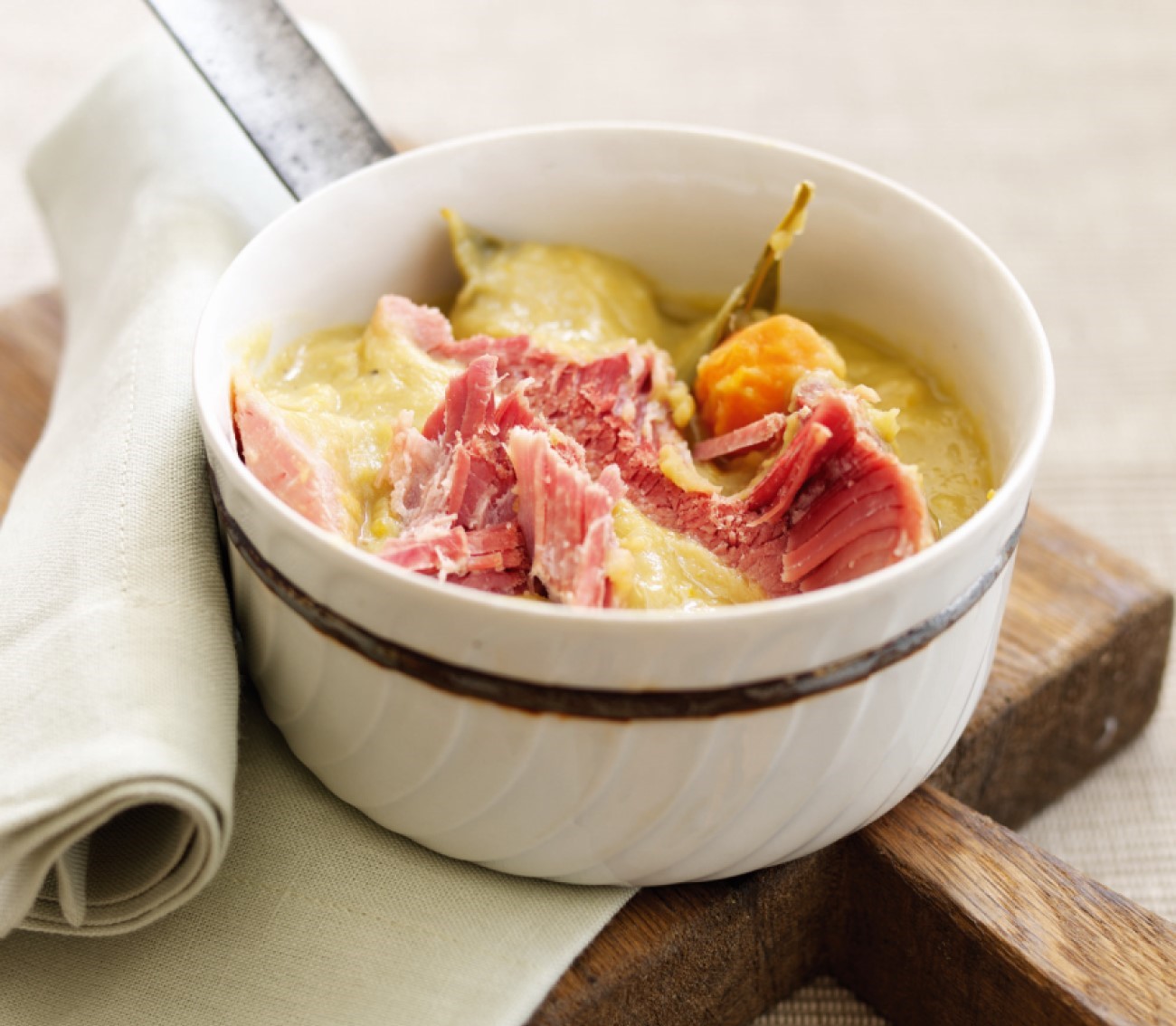 Ham and peas pudding broth in a white ramekin