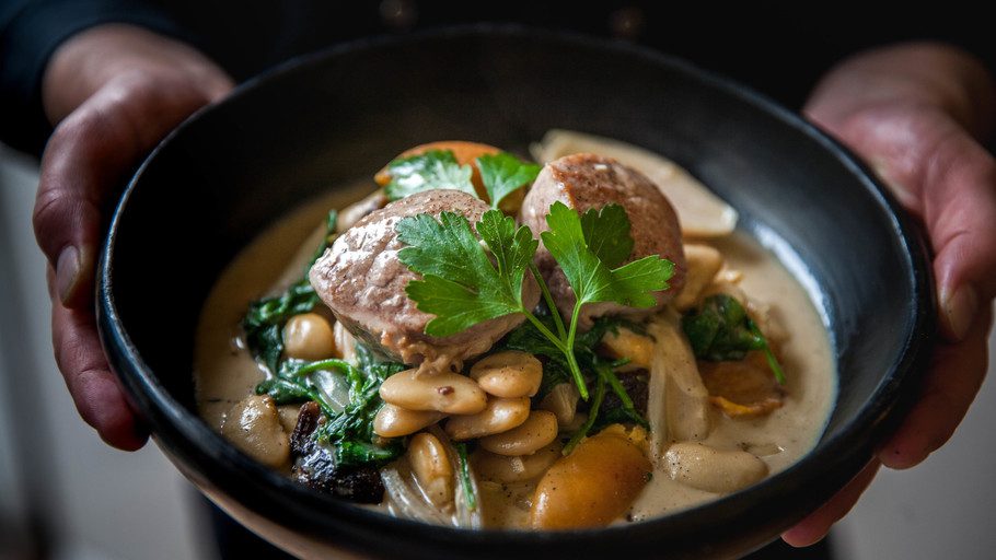 Black bowl filled with a one pot apricot and pork cassoulet