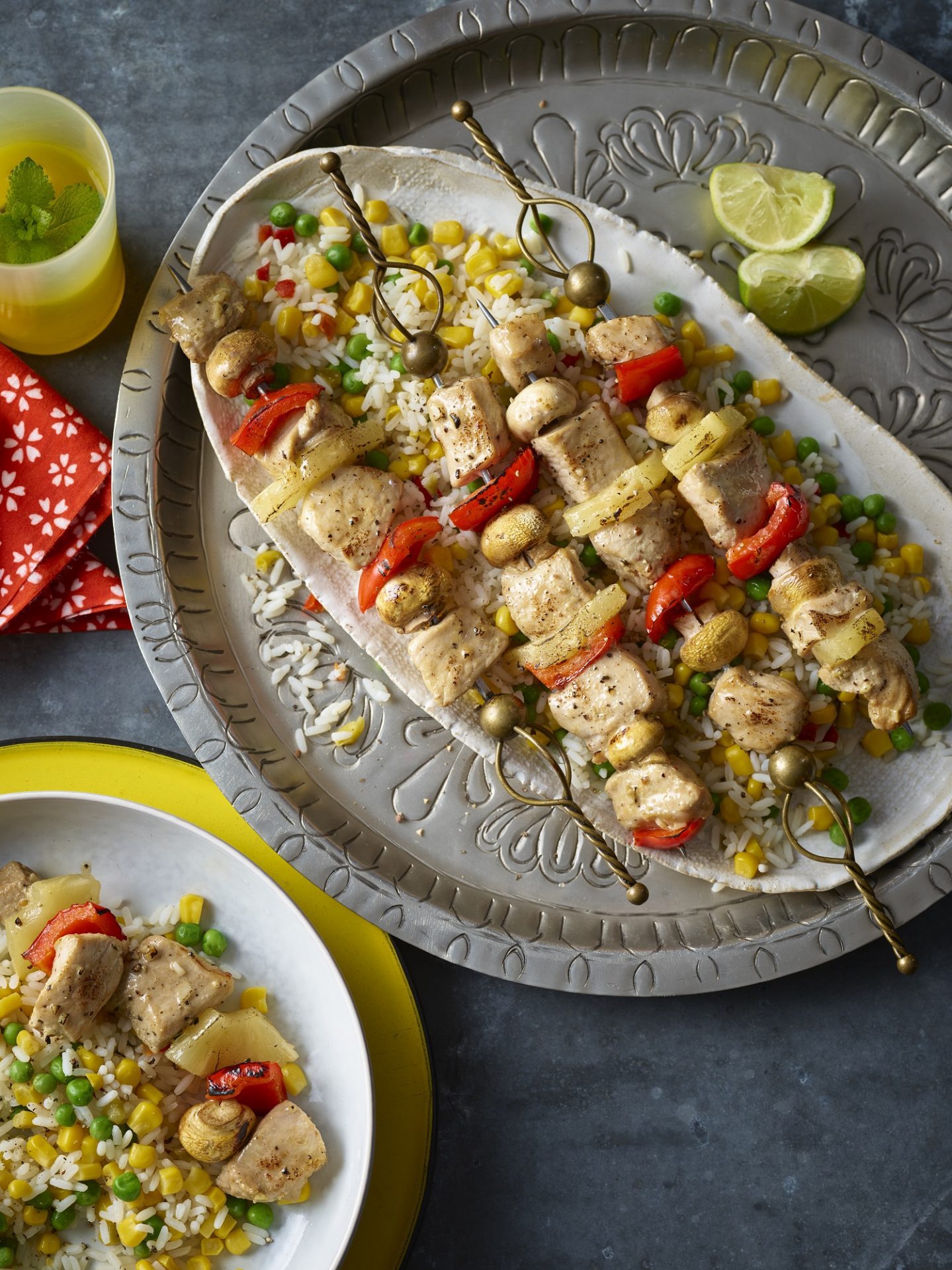 Serving platter with pork and vegetable kebab skewers.
