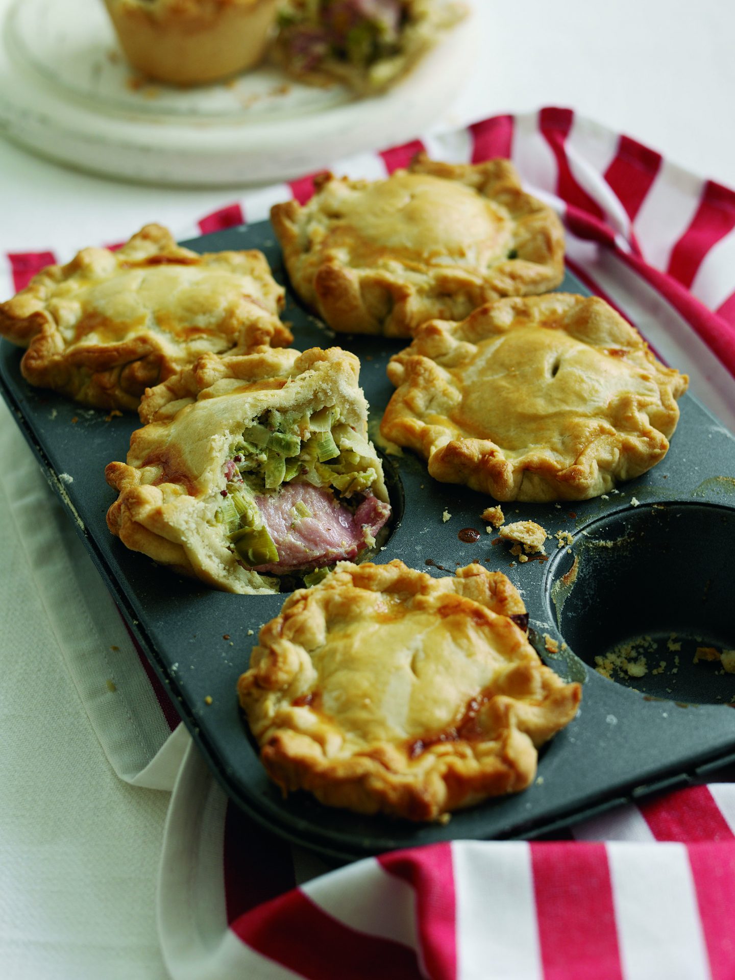 Black cooking pan with five mini bacon and leek pies
