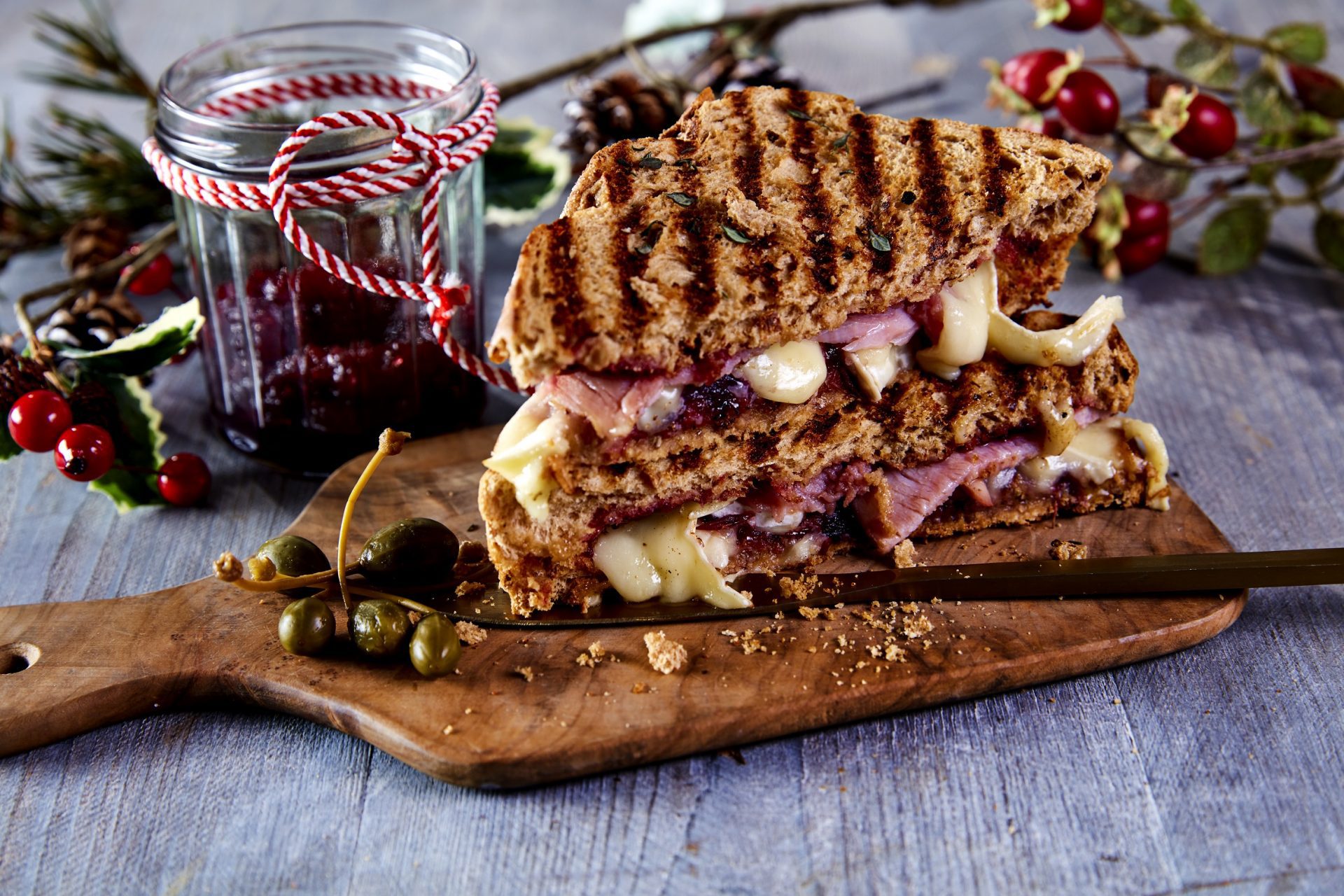 Wooden serving board with a festive themed gammon and cheese toastie