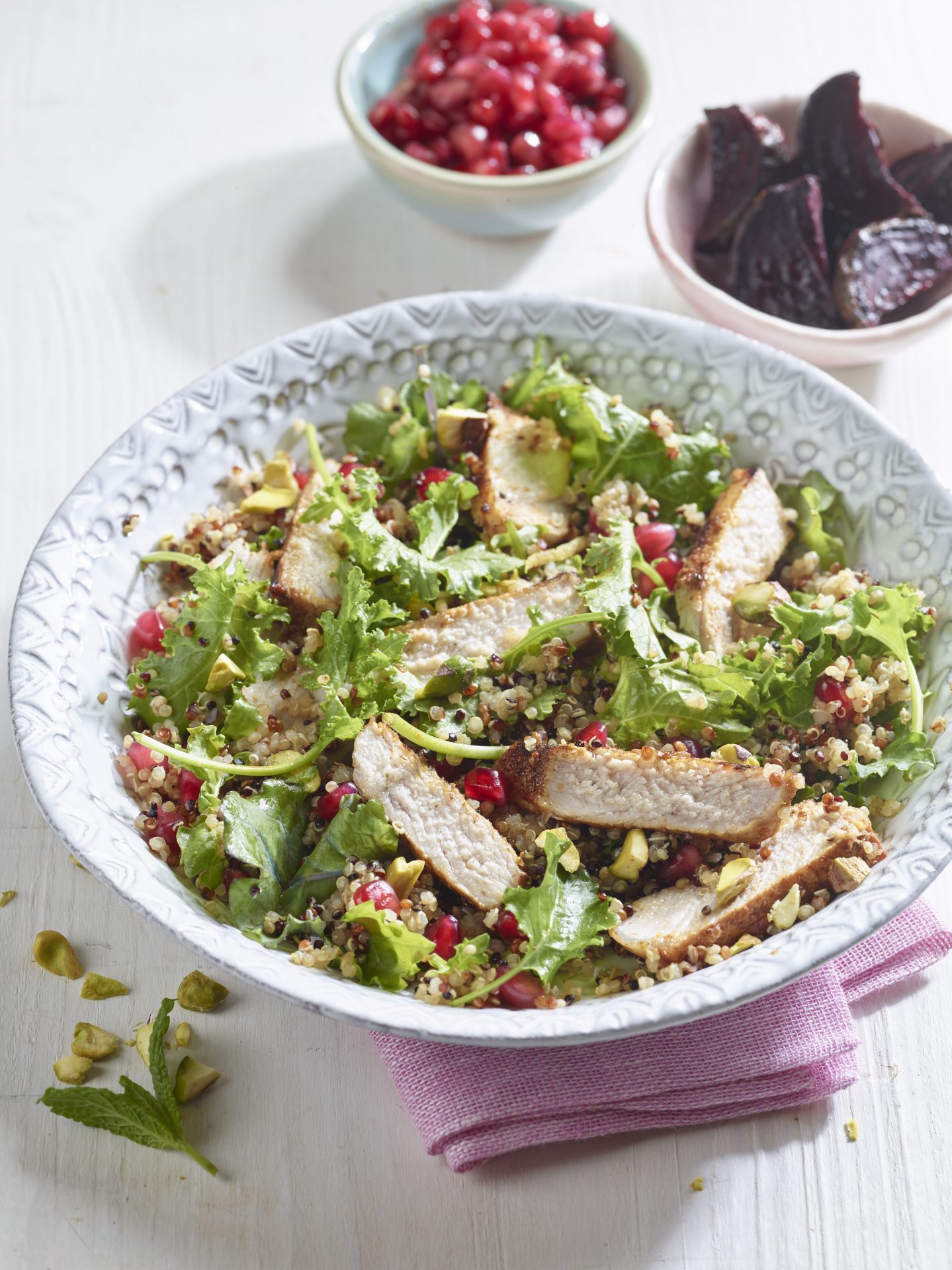 Sliced pork medallion with a pomegranate salad, served in a bowl