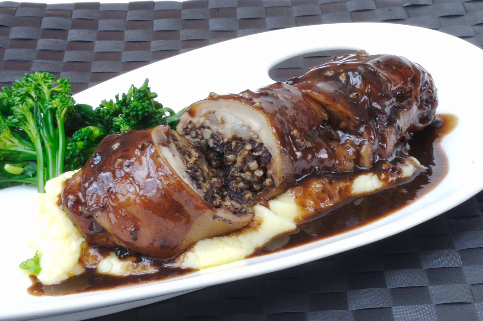 Stuffed pig trotter with black pudding and chestnut on a white plate