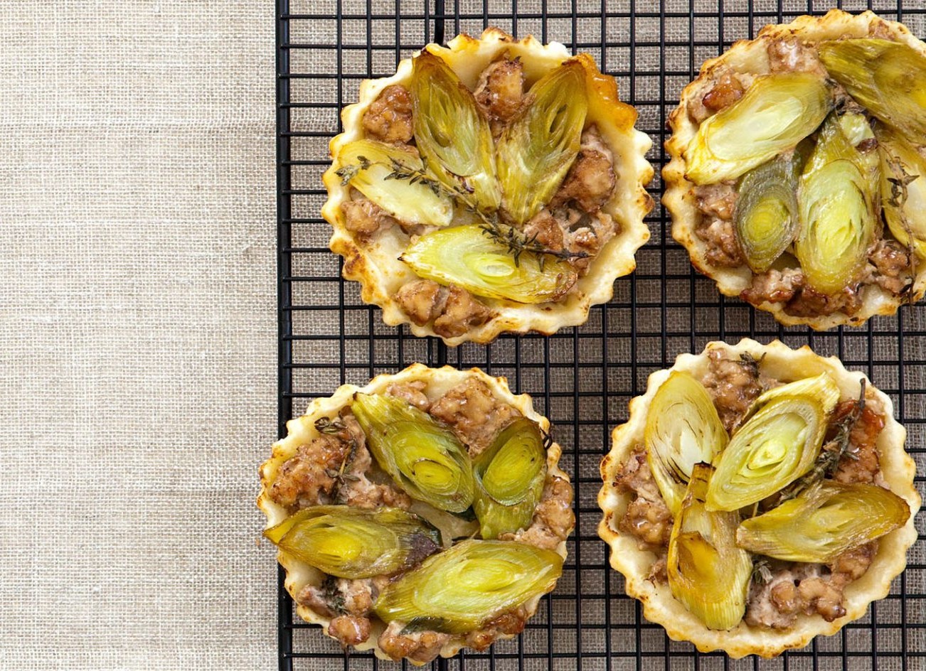 Four pork and leek tarte tatin, on a wire rack