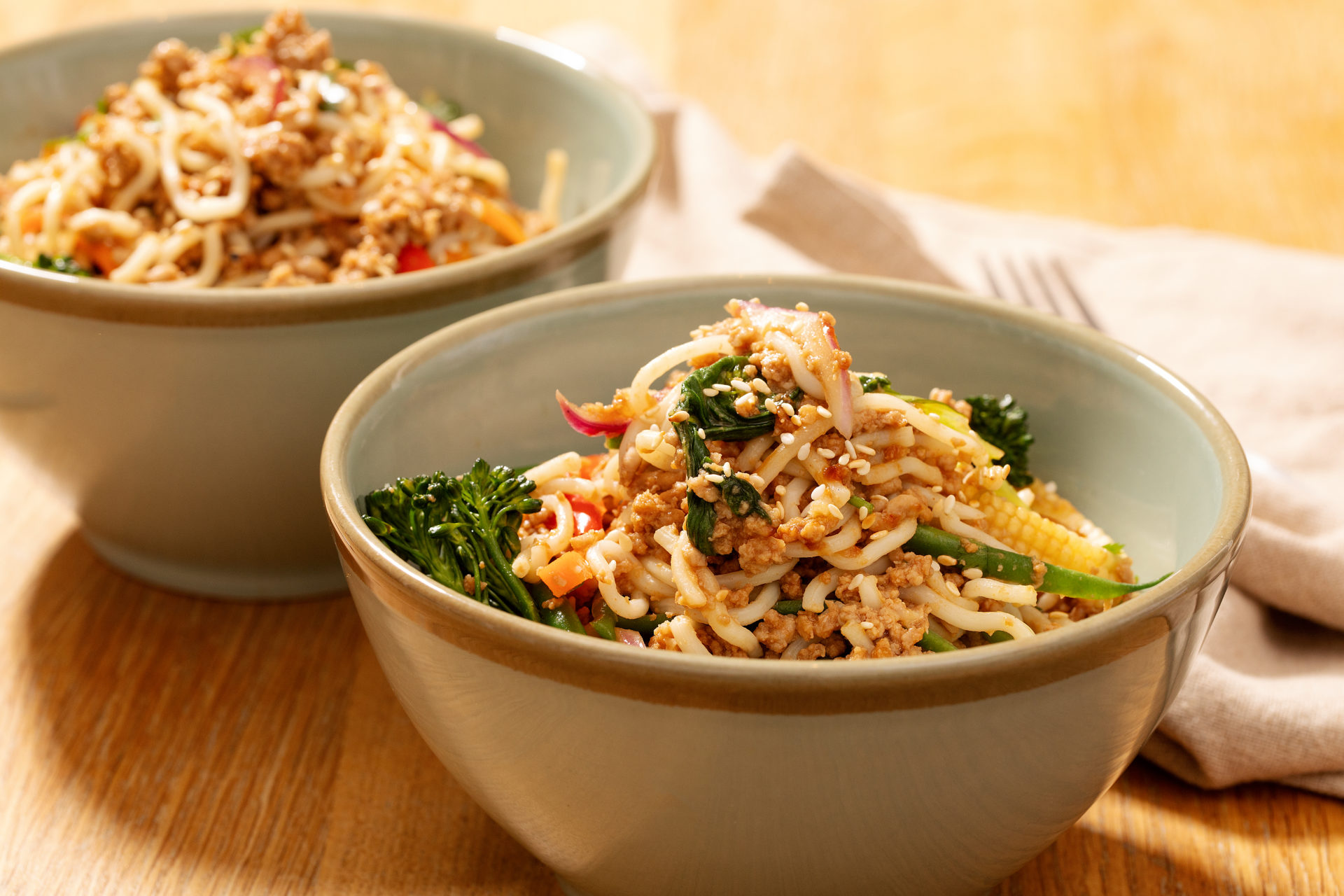 Bowl of quick stirfry pork mince noodles and colourful vegetables.