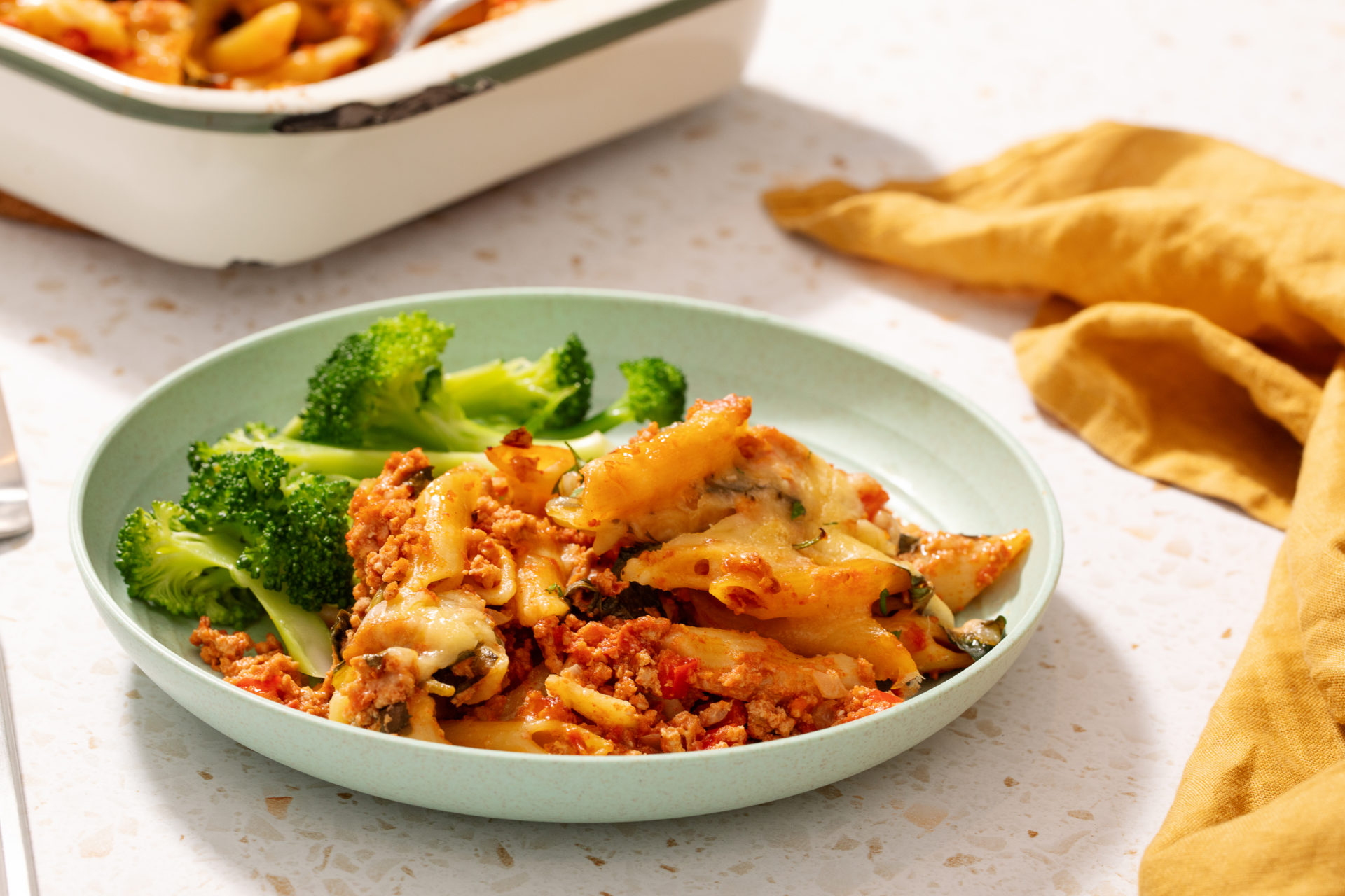 One Pan Pork mince pasta bake plated with greens.
